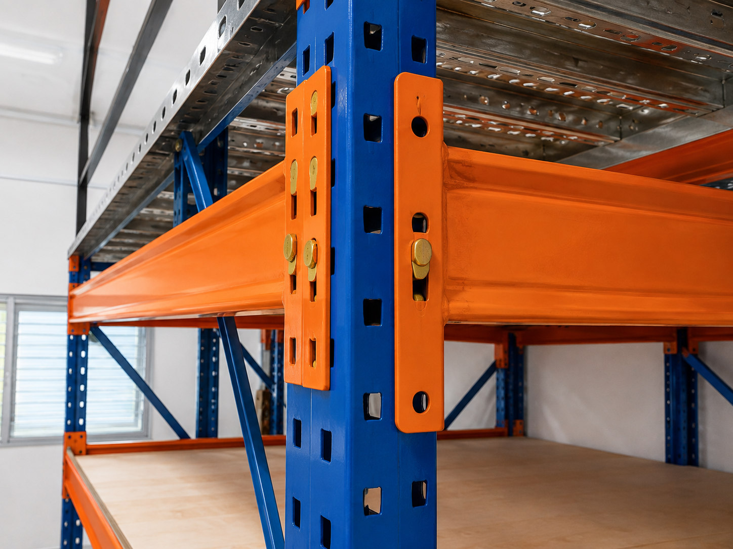 Close-up of orange steel beam to blue upright connector under elevated storage platform