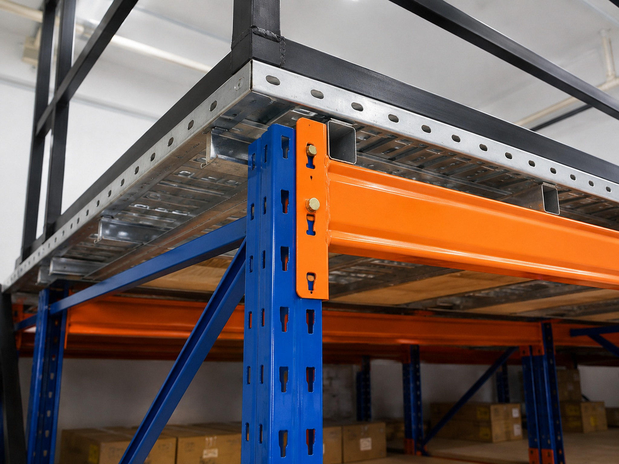 Close-up of orange horizontal steel beam fastened to blue rack upright below slotted floor
