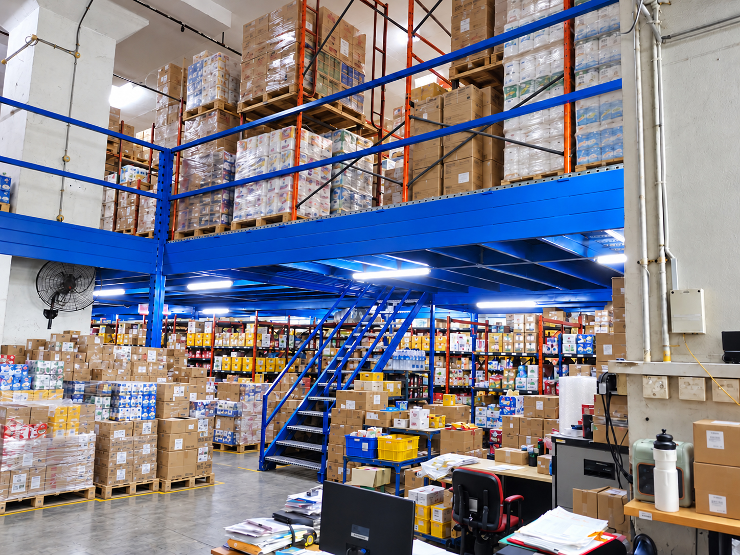 Illustrative distribution warehouse with an upper mezzanine and carton storage zones